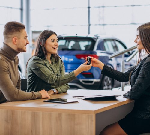 young-couple-talking-sales-person-car-showroom young-couple-talking-sales-person-car-showroom